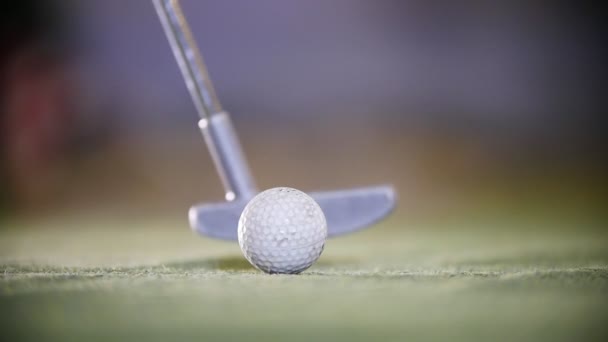 Una persona jugando mini golf. El palo de golf golpeando una pelota de golf . — Vídeos de Stock