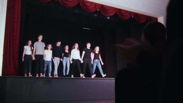 A theater stage. People actors walks towards the audience and bows — Stock Video