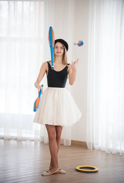 Girl juggles with pins in the studio