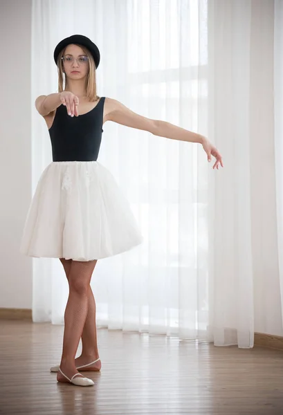 Bailarina no chapéu está esticando o braço para frente, no estúdio — Fotografia de Stock