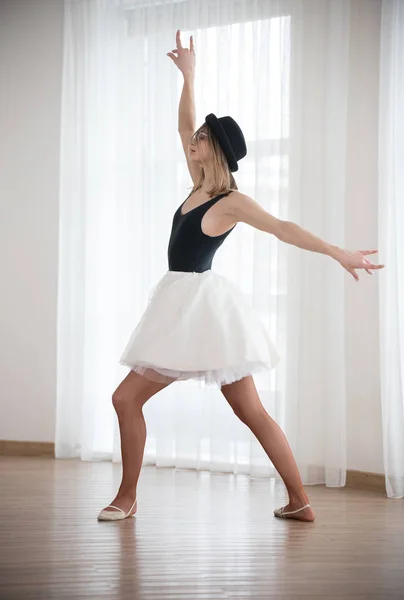 Bailarina no chapéu está dançando levantando as mãos, no estúdio — Fotografia de Stock