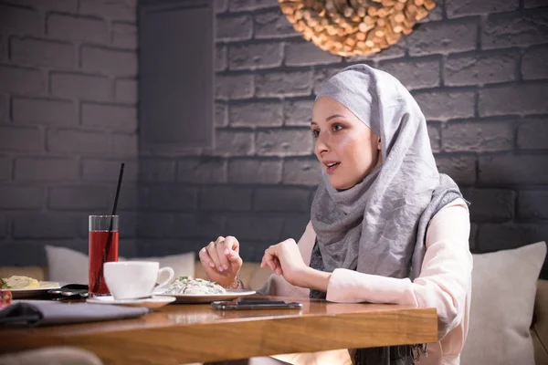 Moslimvrouw zitten aan een tafel in een restaurant — Stockfoto