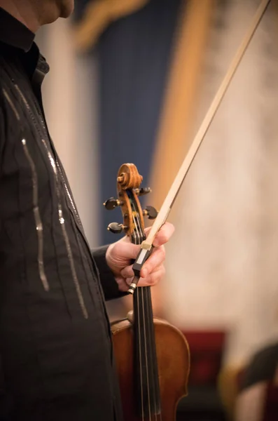 El violinista sostiene el violín en la sala de conciertos —  Fotos de Stock