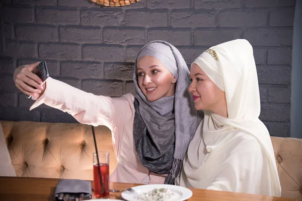 Meisjes in hijabs zijn gefotografeerd in een café — Stockfoto