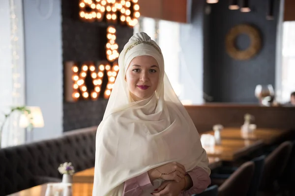Een jonge moslimvrouw in hijab staande in het café — Stockfoto
