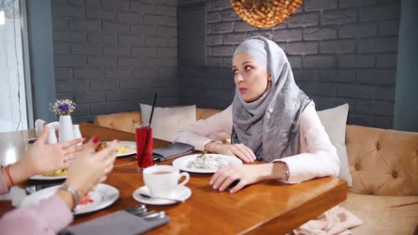 Eine Muslimische Frau Sitzt Einem Café Tisch Trinkt Saft Und — Stockvideo