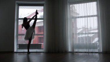 Alacakaranlık bir stüdyoda. Genç balerin studio penceresinde tarafından eğitim