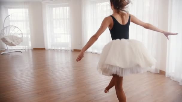 年轻美丽的女芭蕾演员跑了上来, 跳起来, 在空中表演分裂。白色明亮的工作室 — 图库视频影像