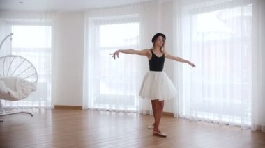 Parlak studio eğitim genç kadın balerin. Tek ayak üzerinde dönüş yapmak