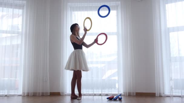 Giovane ballerina in cappello nero giocoleria con un cerchio oggetti in studio luminoso dalla finestra — Video Stock