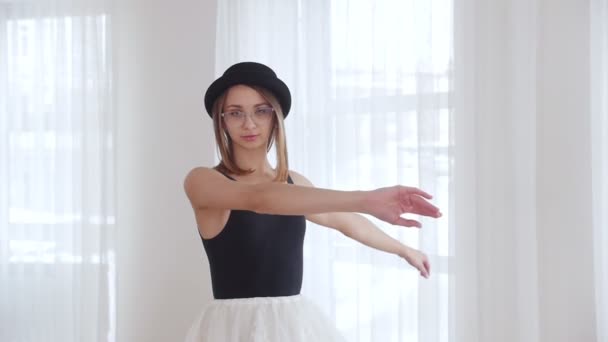 Νεαρή γυναίκα μπαλαρίνα σε μαύρο καπέλο κατάρτισης σε φωτεινά στούντιο. Εκτελώντας την πιρουέτα — Αρχείο Βίντεο