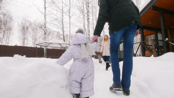 Winter. Jong gezin lopen met hun baby op de binnenplaats — Stockfoto