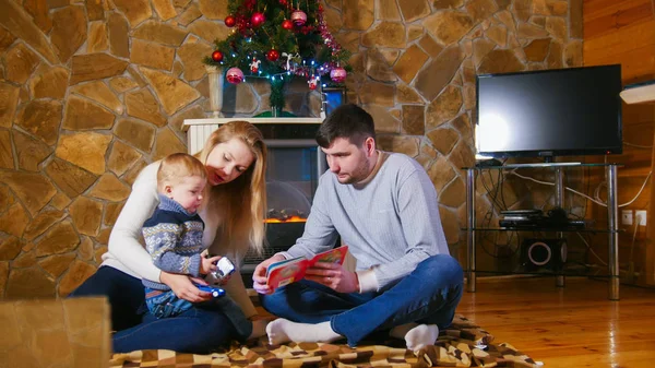 居心地の良い家で床に座って若い幸せな家族 — ストック写真