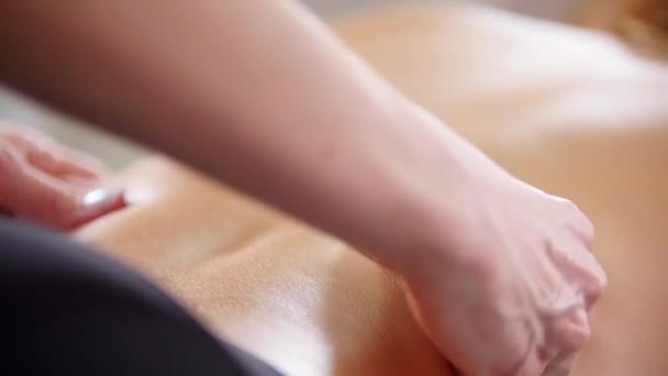 Клініка краси. Молода жінка отримує розслабляючий масаж спини — стокове відео