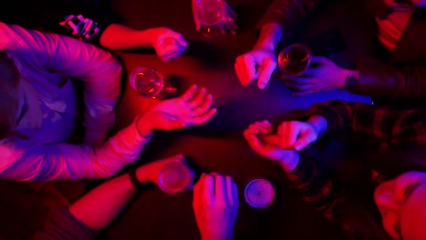 Μπαρ με φωτισμό νέον. Οι άνθρωποι ξοδεύουν το χρόνο μαζί. Παίζοντας ψαλίδια για χαρτί ροκ — Αρχείο Βίντεο