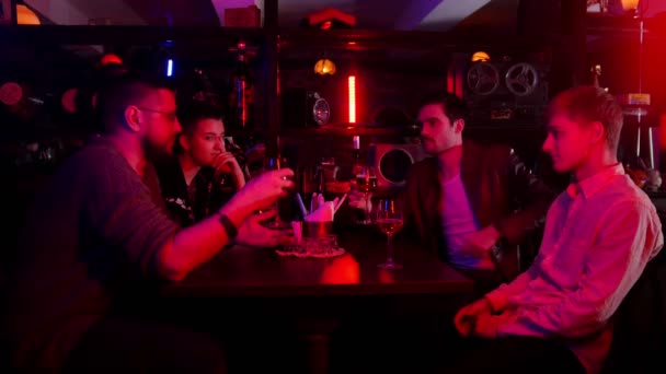 Bar com iluminação de néon. Amigos passando tempo juntos conversando e rindo — Vídeo de Stock