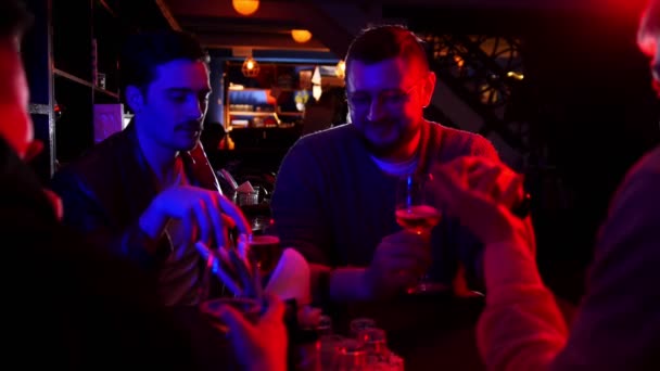 Bar met neon verlichting. Vrienden uitgaven tijd samen praten en drinken bier uit het glas — Stockvideo
