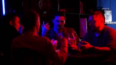 Neon aydınlatma çubuk. Birlikte vakit, içme arkadaşlar. Genç bir adam şaka ve gülüyor herkes söylüyor