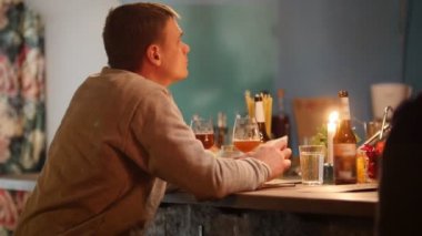 Çekici üzgün adam yumuşak iç aydınlatma ve biri için wating süre light bira içme ile barda oturan. 