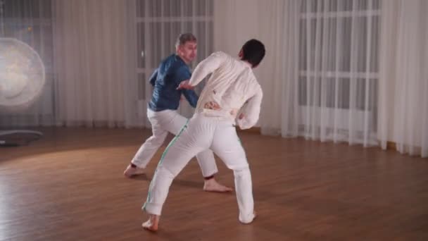 Capoeira. zwei junge Männer, die nachts im Studio trainieren — Stockvideo