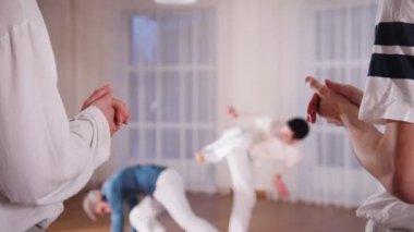 Dövüş sanatları. Akrobatik iki performans gösteren capoeira öğeleri öğrencilerinin el alkışlar süre dostum