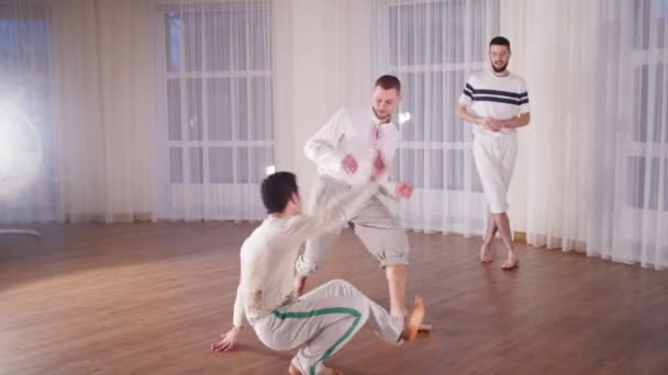 Kampsport. To akrobatiske mand udfører capoeira elementer under sparring – Stock-video