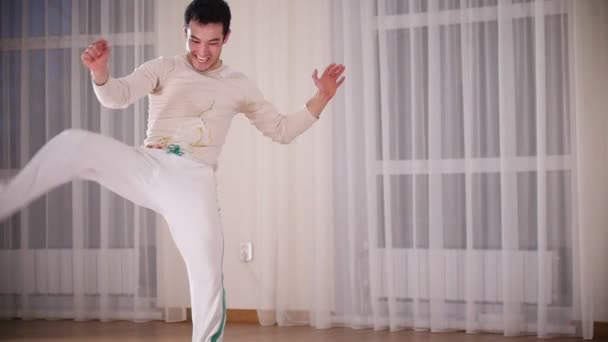 Martial arts. Capoeira. A professional emotional man performs a turnovers leaning on hands — Stock Video