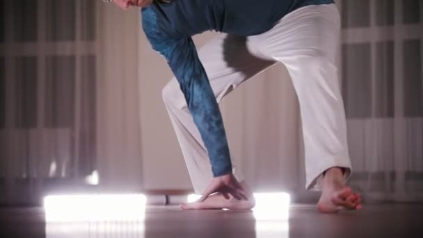 Боевые искусства. Профессиональный человек, исполняющий акробатические элементы капоэйры, опираясь на свои руки — стоковое видео