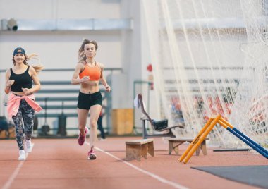İki genç atletik kadın kapalı spor salonu nda çalışan spor şort
