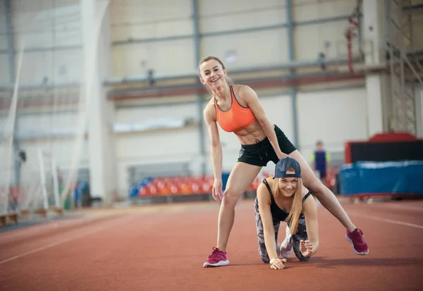 Dos mujeres jóvenes haciendo ejercicios y calentándose juntas — Foto de Stock
