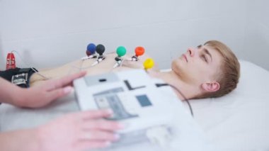 Bir adam bir EKG yordam alma. Makineden yeni çıkmış geliyor sonuçları teyp