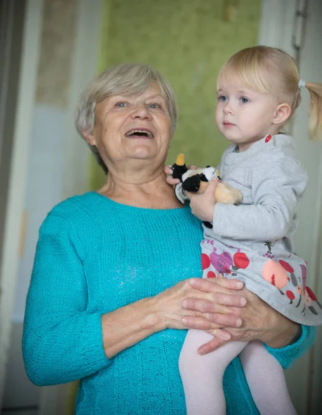 Улыбающаяся бабушка держит маленькую девочку — стоковое фото