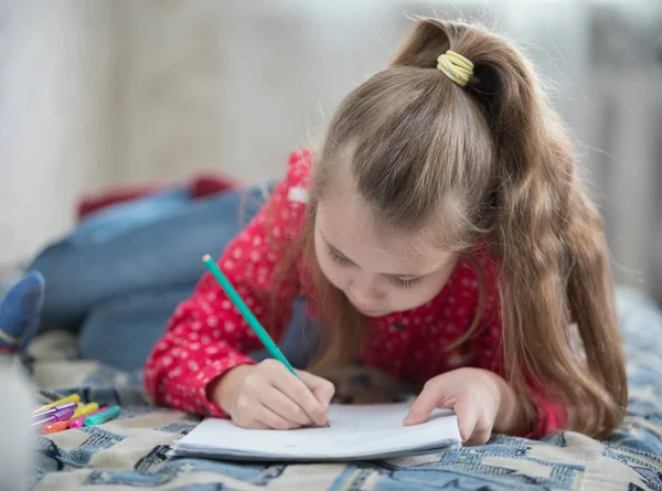 Ragazza trascorrere del tempo a casa disegno mentre sdraiato sul letto — Foto Stock