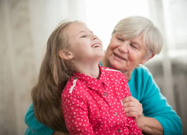 Девушка проводит время со своей бабушкой, смеясь — стоковое фото