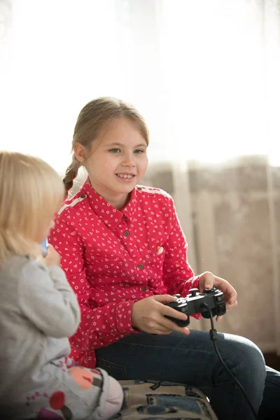 Una chica sosteniendo un joystick y jugando juego —  Fotos de Stock