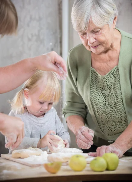 Бабушка печет пирожки со своей внучкой . — стоковое фото