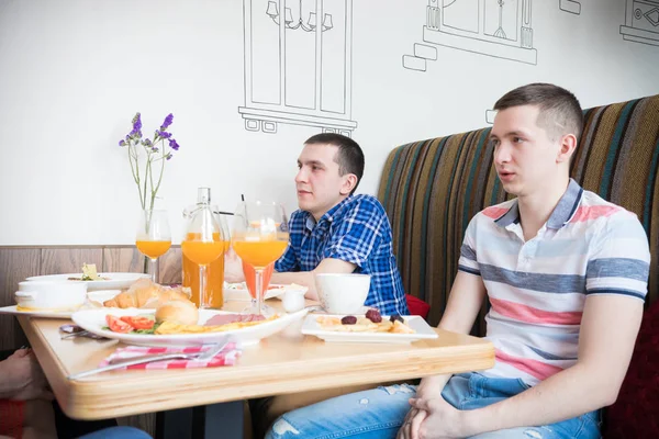 Group of young men friends sitting in cafe
