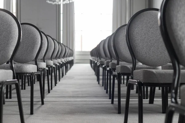 Empty conference hall. Straight rows of chairs. A corridor. Monochrome — Stock Photo, Image