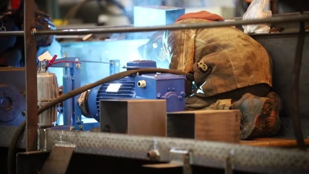 Промышленная концепция Человек-сварщик в грязной рабочей одежде, работающий на заводе — стоковое видео