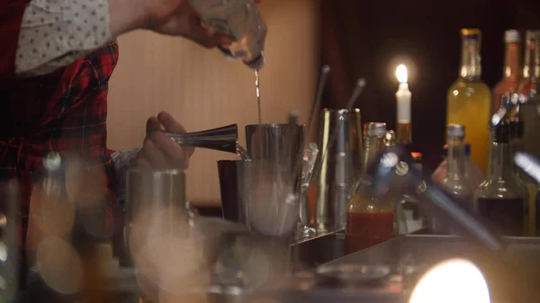 Jovem barman profissional derramando vodka e misturando vodka no copo — Fotografia de Stock
