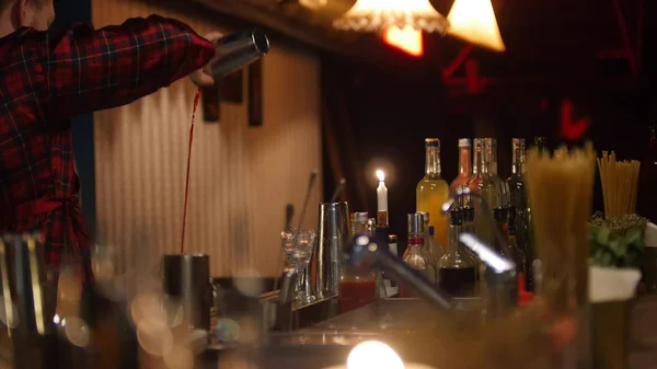 Jovem barman profissional fazendo um coquetel vermelho — Fotografia de Stock