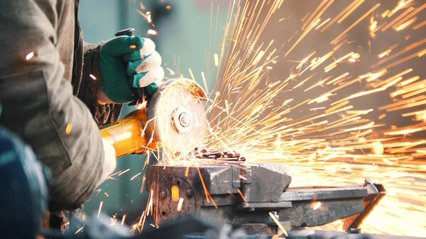 Industrial. Construction site. The man worker grinding. Fire sparkles
