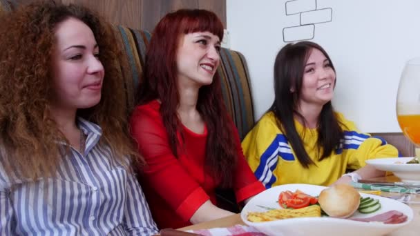 Groep vrienden zitten in een cafe. Drie vrouwen praten met hun vrienden en lachen — Stockvideo