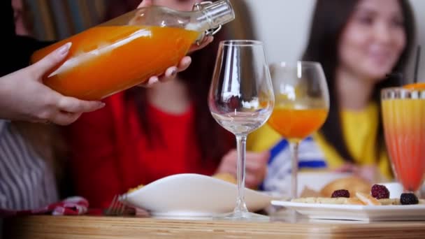 Женщина, наливающая сок из бутылки в стакан — стоковое видео