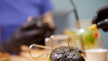 Bir kadın siyah burger alarak ve yemek