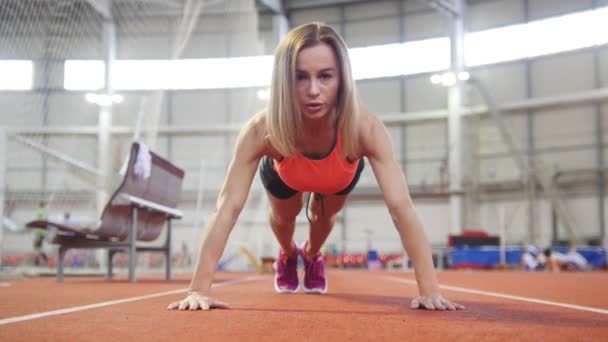 Sportieve vrouw in de sport kleding doet push ups. — Stockvideo