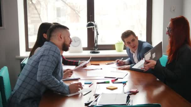 Concept d'entreprise. Une équipe de travail à la conférence. Femme montrant des informations sur son ordinateur portable et ses collègues regardant l'écran 