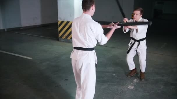 Dois homens a treinar Kendo num parque de estacionamento. Luta de espadas — Vídeo de Stock