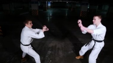 Kimono bir park yeri becerilerine eğitim iki genç adam. Kılıç dövüşü
