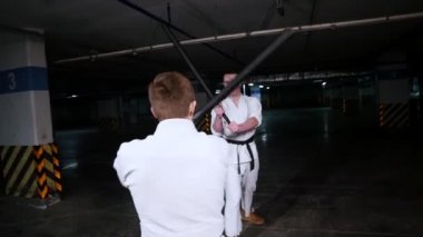 Kimono becerilerini dövüş sanatları eğitim iki genç adam. Kılıç dövüşü